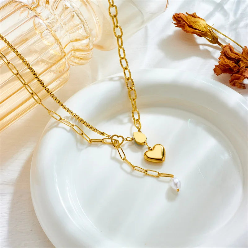 Gold lariat necklace with heart pendants and pearl drop, blue accent bead