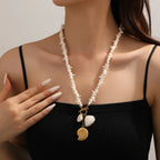 White shell-link necklace with gold-tone conch and shell pendants, layered drop