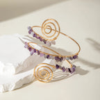 Gold-tone upper arm bracelet with spiral wire and mix of purple and clear stone beads