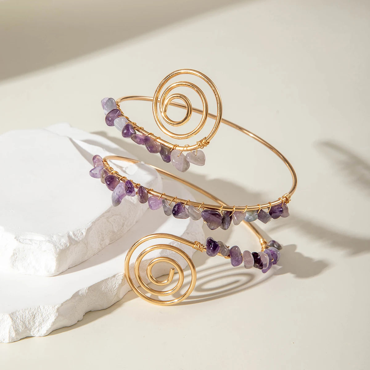 Gold-tone upper arm bracelet with spiral wire and mix of purple and clear stone beads
