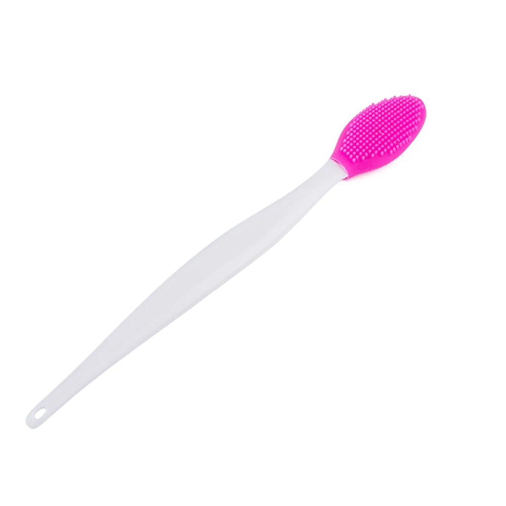 Silicone face cleansing brush with bright pink oval head and long white handle