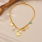 Gold-tone charm necklace with square pendant, heart, star, pearl drops and evil-eye bead