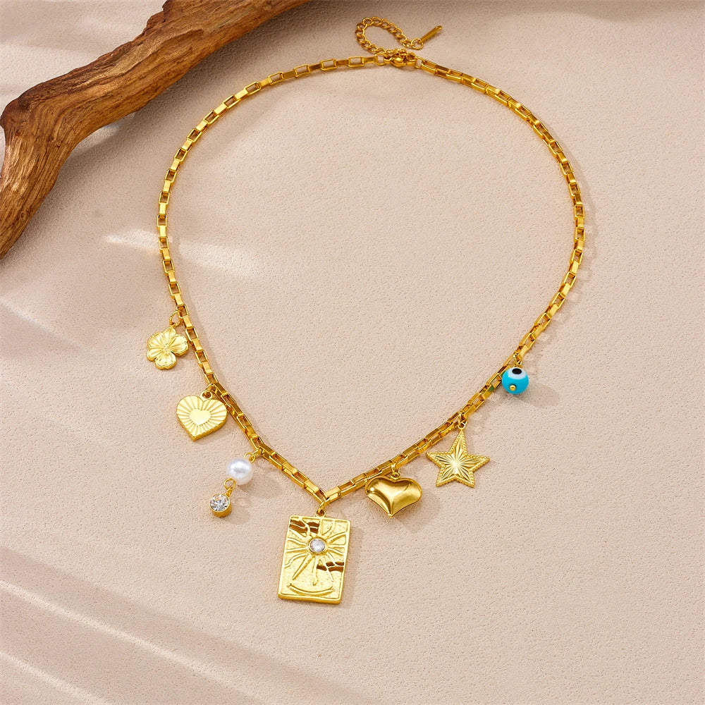 Gold-tone charm necklace with square pendant, heart, star, pearl drops and evil-eye bead