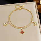 Gold-tone flower charm bracelet with red crystal pendant and white crystal flower details