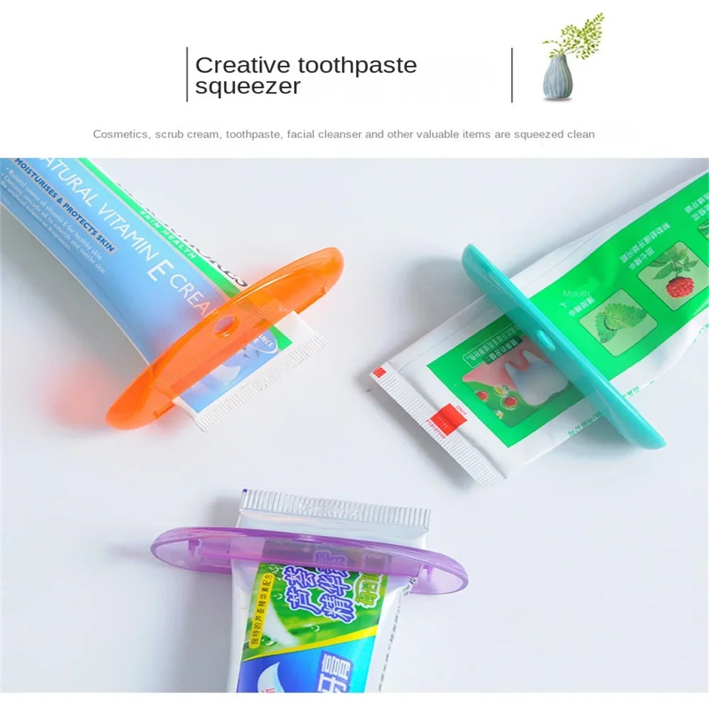 Toothpaste tube squeezer dispenser set in orange, teal, and purple placed with tubes