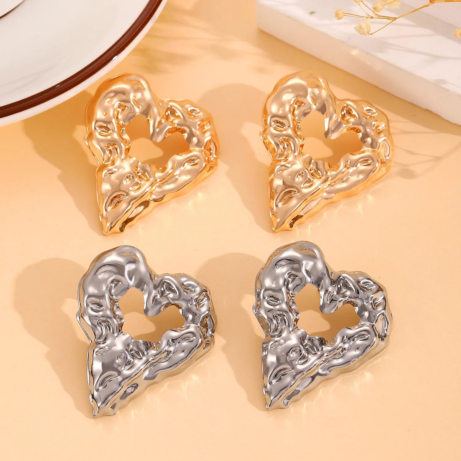 Heart-shaped drop earrings with raised texture in gold and silver, pair