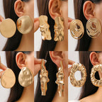 Gold wrinkled oval drop earrings, layered discs and looping details at the ear