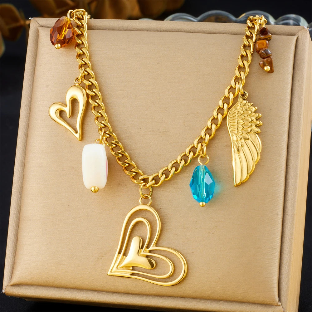 Gold-tone multi-pendant necklace with turquoise teardrop and heart, wing, charm pendants