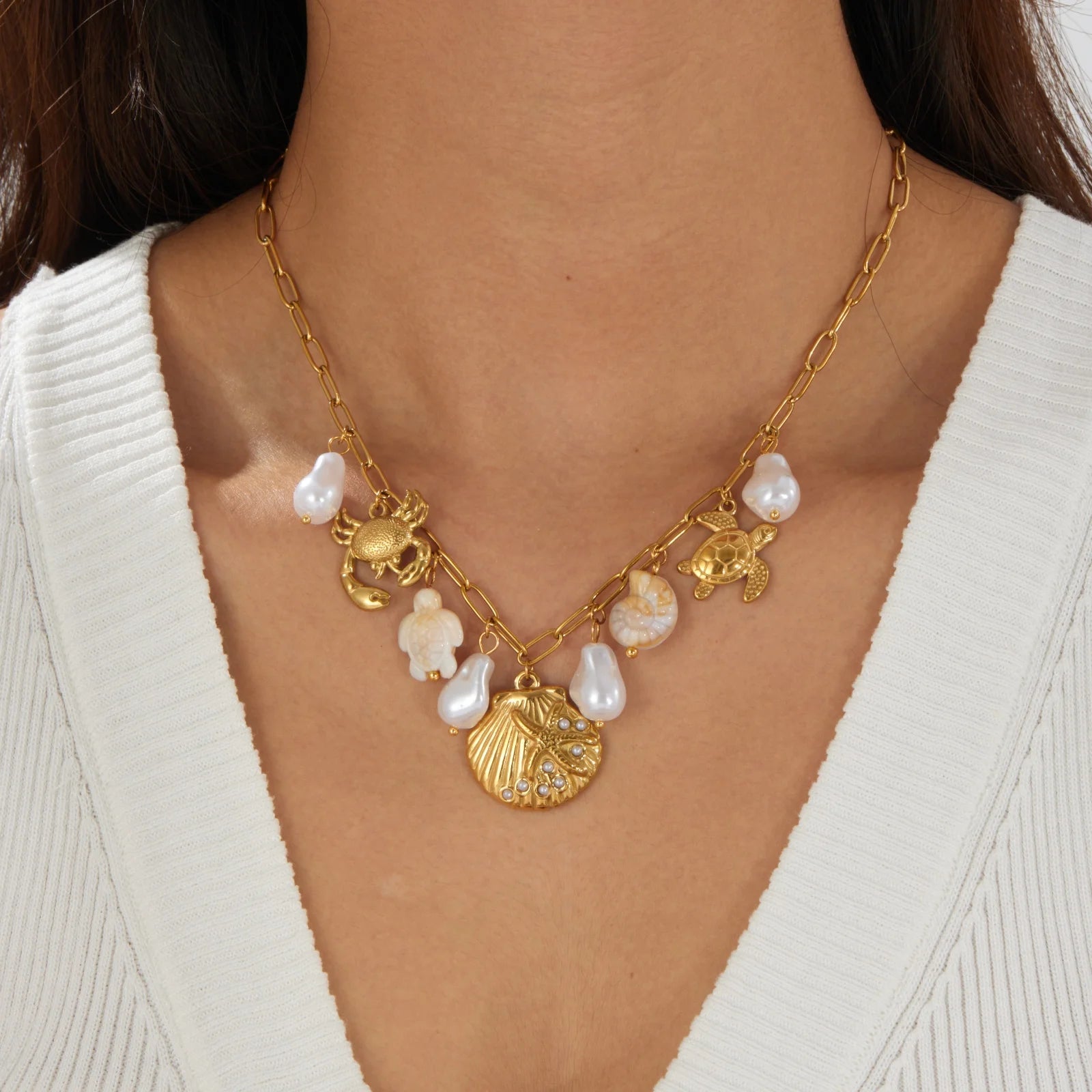 Gold-tone ocean charm necklace with pearls and crab, turtle, shell pendants