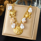 Gold-tone ocean charm necklace with pearl drops and crab, turtle, scallop shell pendant