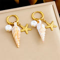 Gold hoop earrings with dangling starfish, pearl beads, and conch drops