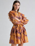 Orange ruffle mini dress with V-neck and tie waist, layered puff sleeves.