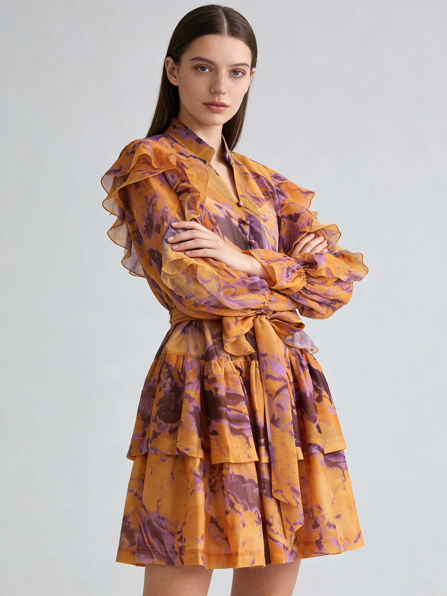 Orange ruffle mini dress with V-neck and tie waist, layered puff sleeves.