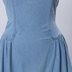 Light blue denim dress close-up of fitted bodice and gathered skirt ruffle