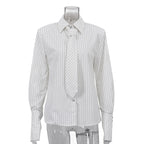 White striped long sleeve shirt with tie collar and button front, hanging on mannequin