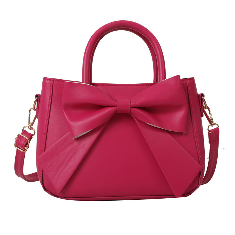 Rose pink bow-trimmed small square handbag with top handles and shoulder strap