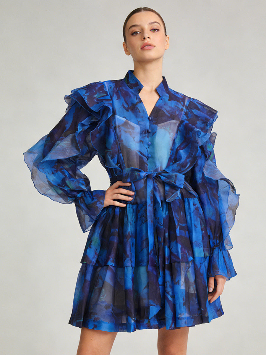 Blue ruffle mini dress with V-neck and tie waist, voluminous ruffled sleeves.