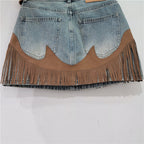 Front hem of blue denim skirt with tan scalloped insert and dangling fringe