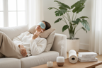 Cozy cream sofa with white throw blanket and decorative pillows